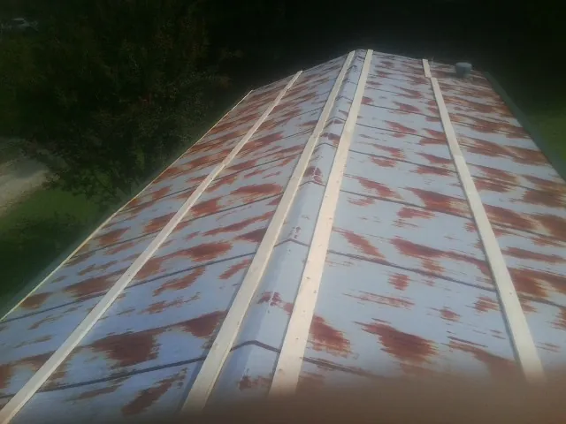 Rusted metal roof panels with new wood purlins before replacement — Storm Damage Roof Repair in Brooksville by Roofing Brothers